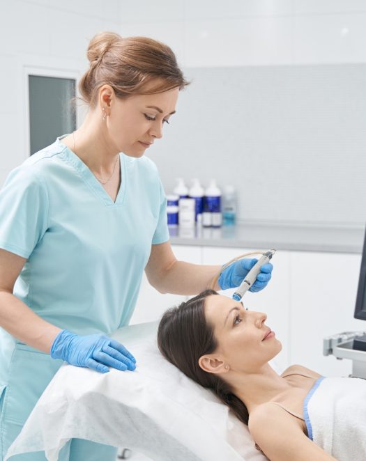 Doctor beautician performing hydrafacial treatment in clinic Doctor beautician performing hydrafacial treatment in clinic